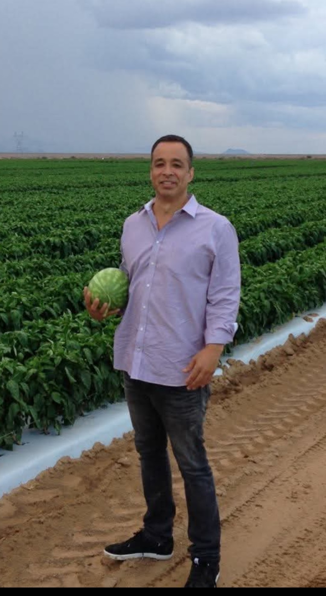 Edward May standing in a watermelon field